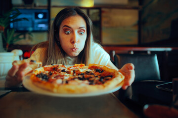 Hungry Woman Starring at a Pizza Dish in a Restaurant. Girl blowing on her freshly baked dish
