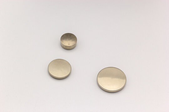 Three circular lithium batteries of different sizes on a white background II