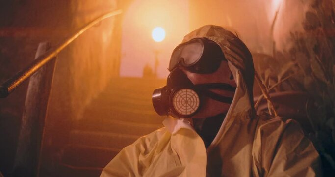 The video shows a person in a protective suit and gas mask sitting in a dark nuclear bunker, highlighting survival preparedness after a nuclear event.
