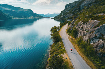 Aerial view of a road along a lake in Norway, with mountains and greenery on both sides
