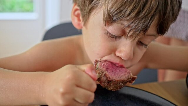 Young Child Enjoys A Piece Of Perfectly Cooked Lamb Rack