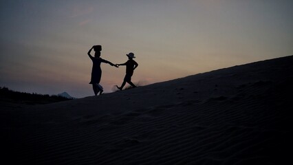 Woman walking on the desert sand dunes aerial view in Ninh Thuan, Vietnam