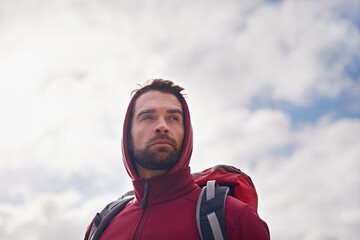 Sky, thinking and man with backpack, hiking or camping in nature for adventure and peace. Contemplation, vacation and male person in trip, thoughtful and journey for holiday and break to relax