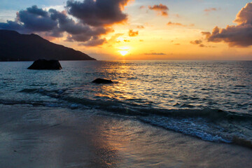 Fototapeta premium Golden sunsets seen from the rugged coastline near Beau Vallon Beach