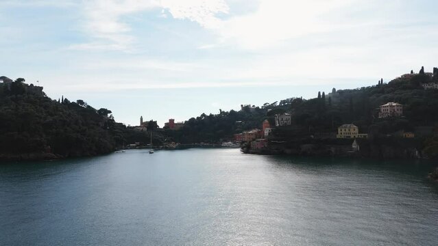 Mediterranean sea gently laps against the quaint Portofino shores, Italian Riviera charm, sunny day