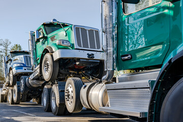Day cab green big rig semi truck tractor towing another semi trucks on a fifth wheel hitch