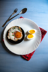 Healthy food slices of egg and egg poach on a white plate. Top view, selective focus.