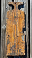 A wooden plank with a hole in the middle. The wood is old and has a rustic look
