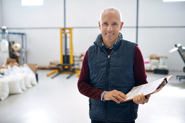 Man, smile and manager of warehouse with clipboard for stock taking in manufacturing, distribution...