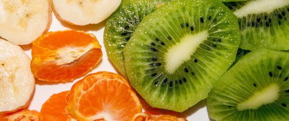 Banana.Kiwi.Mandarin.Slicing of fruits.Fruit background.Fruit mix.