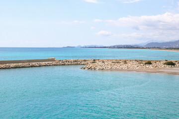 View on rocky beach with clear blue sea and breakwater at the sunny day. Mediterranean Sea near to Demre, Turkey.