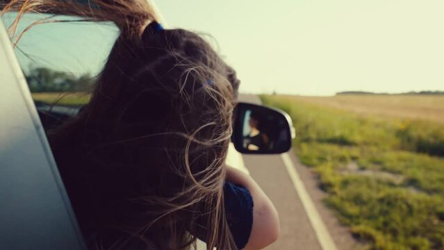 little girl dreams car window, following the road into the sunset. wind plays with hair, symbolizing freedom childhood. Family travel summer filled with joy holidays, child kid daughter childhood