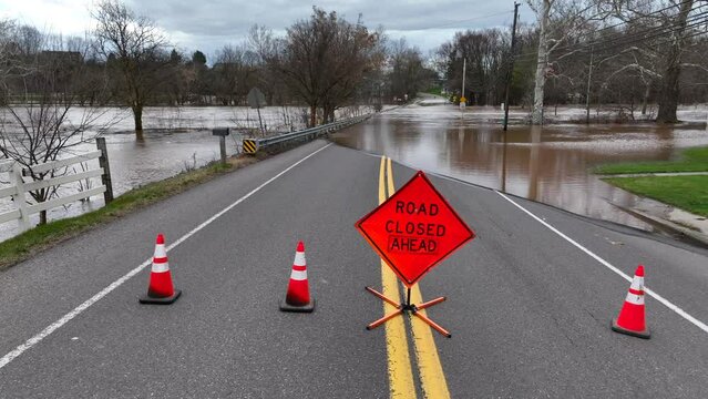 Road closed ahead warning sign on flooded road in USA. Aerial truck shot with flooding theme.