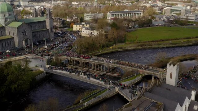Crowded Salmon Weir Bridge, St. Patrick's Day In Galway, Ireland. aerial, slow motion