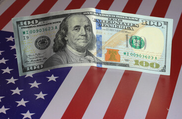 Dollar bills lie on the USA flag