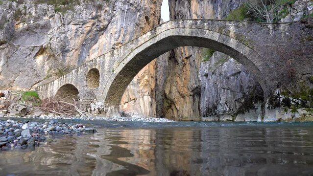 River Waters in Portitsa Grevena Greece. Historic Old Stone Bridge and Canyon in the Greek Mountains. Static Shot 4K