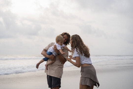 Parents, mom and dad with little baby on the beach. Traveling, child.