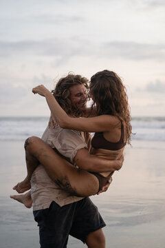 Young cheerful happy couple in love fooling around on the beach.