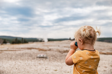 Child looking through binoculars at Yellowstone National Park la