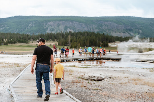 Father and son walking down boardwalk at Yellowstone National Pa