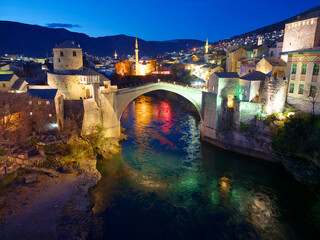 Night view of the Old Bridge in Mostar city in Bosnia and Herzegovina. Neretva river. Unesco World Heritage Site. People walking over the bridge.