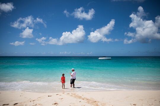 Rear View Wide Angle of Man and Daughter Standing on Caribbean Beach