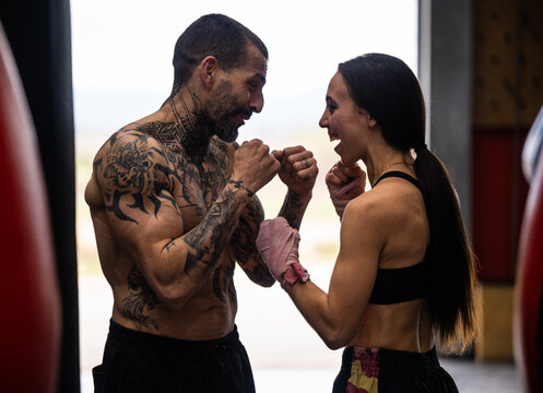 Cheerful couple practicing Muai Thai in gym