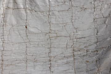 Old cracked white building cover tarp, full-frame background and texture.