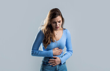 Woman with hand on stomach because nausea, painful disease feeling unwell. Ache concept. Stomach...