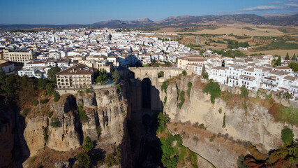 Fototapeta na wymiar Aerial drone view of The Puente Nuevo, New Bridge in Ronda. White villages in the province of Malaga, Andalusia, Spain. Beautiful village on the cliff of the mountain. Touristic destination. Holidays.