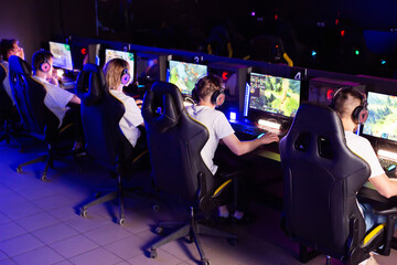 Team of gamers playing video game on PC at computer club cyber sport tournament. E-sport...