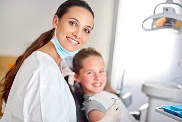 Young girl and dentist with smile in office on chair, appointment or results in consulting room. Professional, child and dental work, oral hygiene or working or care with tools, patient or calm