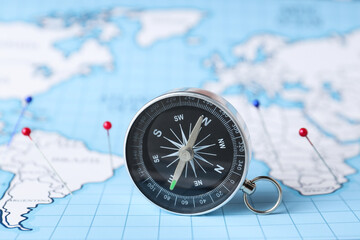 Compass on the background of the world map.