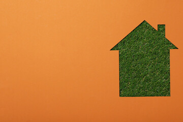 The house is cut out of paper on the grass