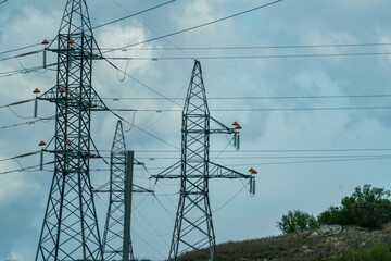 High voltage towers with sky background. Power line support with wires for electricity transmission. High voltage grid tower with wire cable at distribution station. Energy industry, energy saving