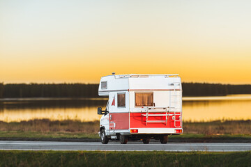 Vintage two-colored recreational vehicle on the road with a beautiful landscape background. - obrazy, fototapety, plakaty
