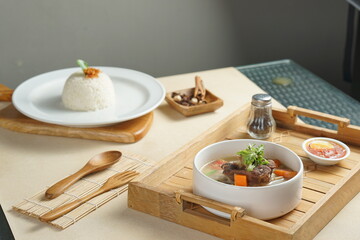 Bowl of meat soup on a wooden table