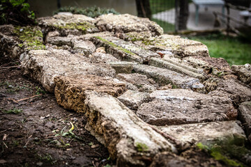 A male craftsman builds a raised bed or wall from rough stones