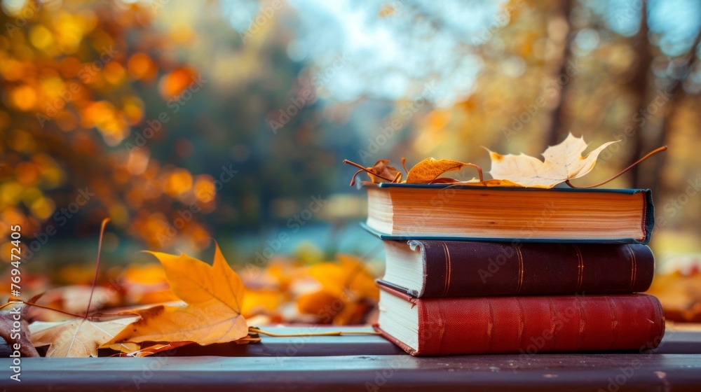 Poster a stack of books in various colors placed neatly on top of a wooden table surrounded by autumn leave