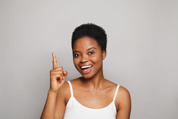 happy woman pointing up on white background - 769475467