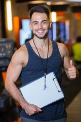 Fotobehang Persoonlijk smiling personal trainer in gym  © auremar