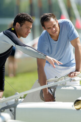 young sailing instructor instructs with student