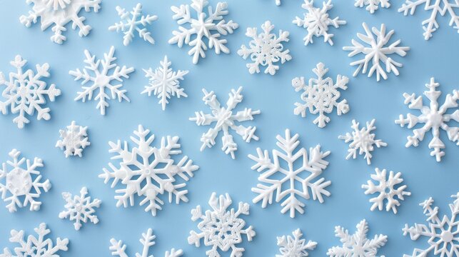 Snowflakes in white falling on a soft blue background creating a winter theme
