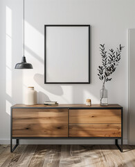 A simple modern room with white walls, a sideboard and hanging lamp in the background. A black thin frame hangs on wall above cabinet