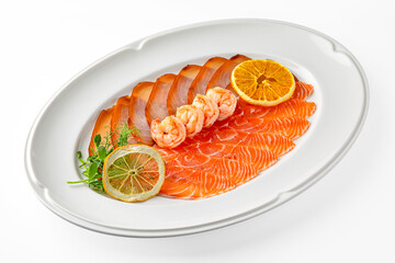 Sliced delicacy fish: salmon and butter fish and shrimp on a white plate. Banquet festive dishes. Gourmet restaurant menu. White background.