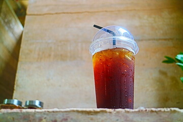 Close up of  a cup of ice coffee on an earthen table