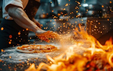 Cook adding a handful of flour to pizza on a fiery kitchen backdrop. - obrazy, fototapety, plakaty