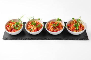 Salmon buffet appetizer, tartare on a white plate. Banquet festive dishes. Gourmet restaurant menu. White background.
