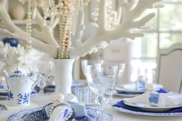 table with a white coral chandelier above, bluewhite porcelain, and pearl napkin rings