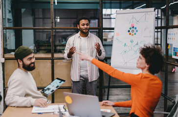 Cheerful diverse colleagues discussing playfully in office